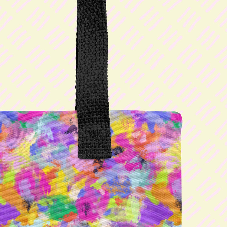 A close-up of the Watercolour Rainbow Tote Bag by My Favourite Colour is Rainbow, showing the sturdy black handle. 
 The bag, made from durable polyester, features an abstract multicoloured pattern in pink, yellow, blue, and purple.