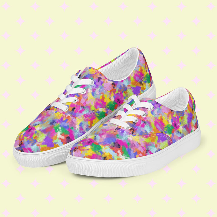 Watercolour Rainbow Canvas Sneakers by My Favourite Colour is Rainbow feature vibrant abstract patterns in pink, yellow, purple, blue, and green with white laces and soles on a light background with subtle pink patterns.