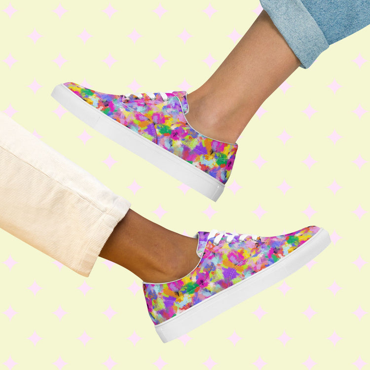 Two pairs of legs in light-toned pants with rolled cuffs sport My Favourite Colour is Rainbows Watercolour Rainbow Canvas Sneakers, featuring vibrant abstract patterns on a pink diamond background.
