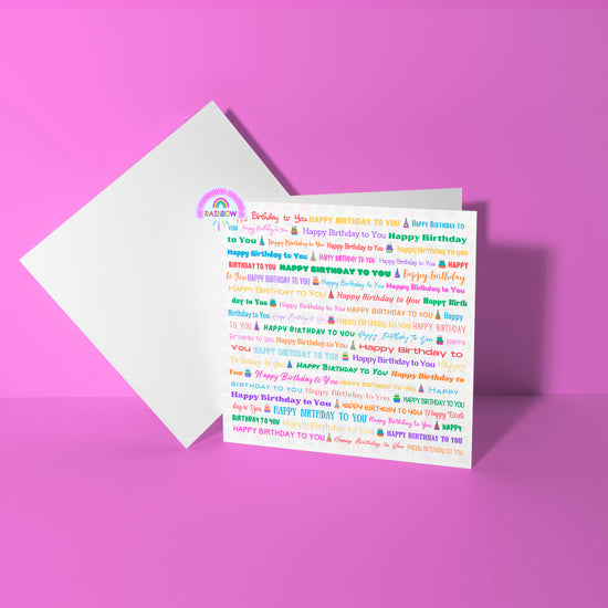 The Happy Birthday Typography Card by My Store features a pink background with multicolored Happy Birthday to You text, partially tucked in an envelope, and includes a rainbow and cloud illustration, perfect for sending joyful celebration wishes.