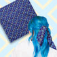 Two views of the 'Bloomscape' Bandana by My Favourite Colour is Rainbow.  At top left, a flat lay of the bandana.  At bottom right, a person with vibrant blue hair is seen from behind, wearing the bandana in her hair.  The bandana features a design of large flowers and small hearts in shades of blue and yellow on a royal blue background.