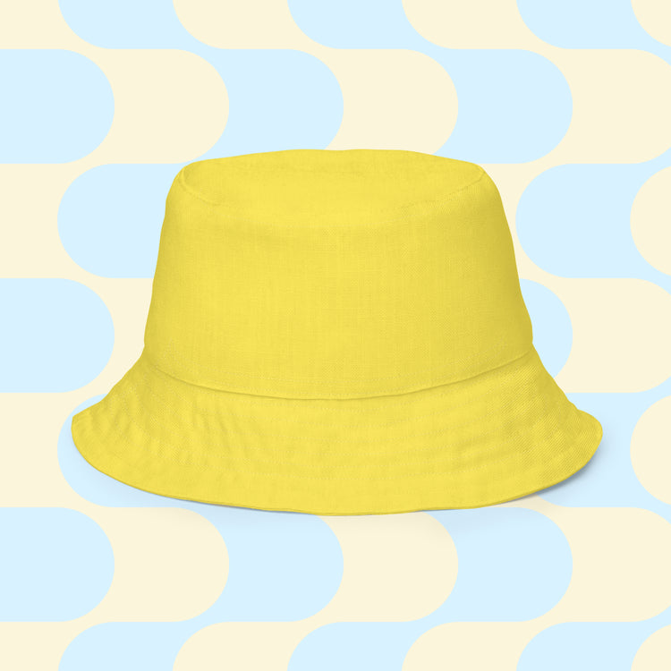 A Bloomscape Reversible Bucket Hat by My Favourite Colour is Rainbow is shown with the solid yellow side.