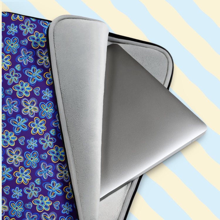 The Bloomscape Laptop Sleeve by My Favourite Colour is Rainbow features a design of large flowers and small hearts in shades of blue and yellow on a royal blue background. The plush faux fur interior is partially open, revealing a laptop.  The print is only on one side; the other side is black.