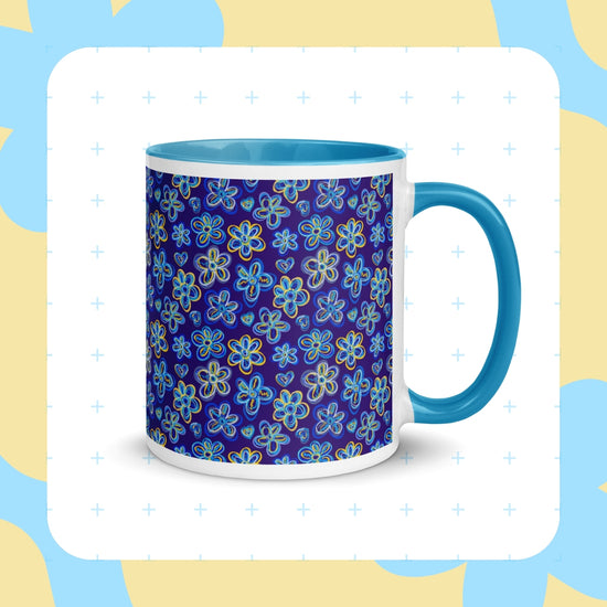 The My Favourite Colour is Rainbow Bloomscape Mug is a white ceramic mug with a blue interior and handle, featuring blue and yellow flowers on a dark blue background, complemented by soft blue and beige patterns—perfect for your morning coffee ritual.