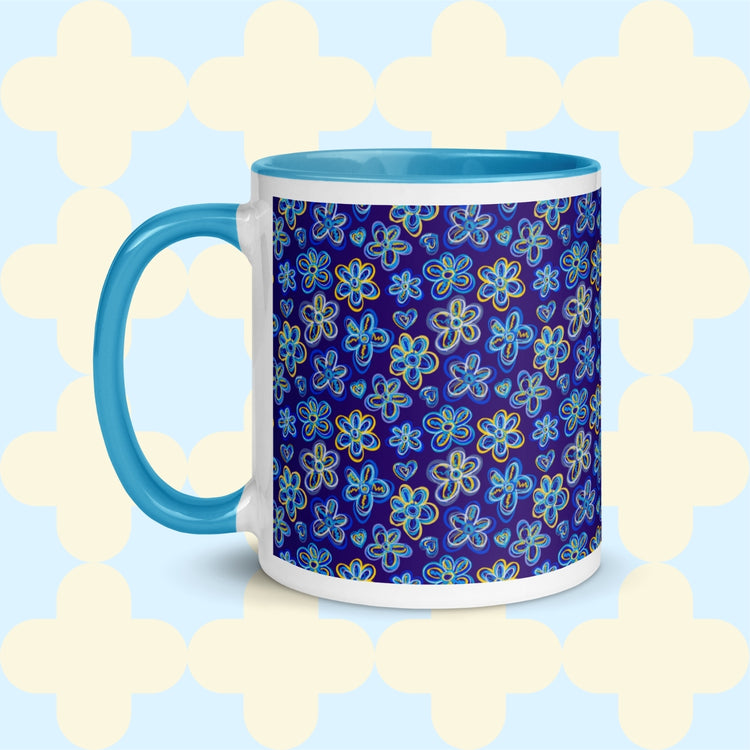 Introducing the Bloomscape Mug by My Favourite Colour is Rainbow—a coffee mug featuring a blue handle and interior, adorned with vibrant floral designs against a dark blue backdrop. Its elegant style elevates your coffee ritual, contrasting beautifully with a light background and subtle geometric pattern.