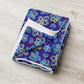 The Bloomscape Throw Blanket by My Favourite Colour is Rainbow is neatly folded on a light wooden surface, showcasing a blue, yellow, and white floral design against a royal blue backdrop.