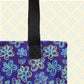 The Bloomscape Tote Bag by My Favourite Colour is Rainbow is a spacious tote bag featuring a vibrant flower pattern on a dark blue background, with black handles. 