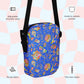 The Blue Summer Sorbet Mini Crossbody Bag by My Favourite Colour is Rainbow features a colorful nautical pattern with fish and seashells on a pastel checkered background, sturdy water-resistant fabric, an adjustable black shoulder strap, a two-way zipper, and inside and outside pockets.