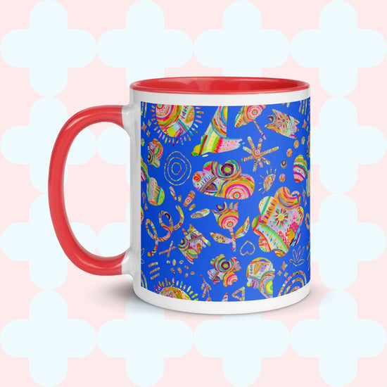 Discover the Blue Summer Sorbet Mug by My Favourite Colour is Rainbow, showcasing a vibrant summer design. It features a red handle and rim with abstract skulls on a blue backdrop, accented with hearts, flowers, and light geometric shapes.