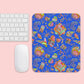 A computer keyboard and mouse sit beside the Blue Summer Sorbet Mouse Pad by My Favourite Colour is Rainbow, featuring colorful abstract designs set against a pink background.