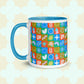 The Colour Block Mug by My Favourite Colour is Rainbow features a vibrant geometric design, showcasing colorful circles, squares, stars, and waves in blue, green, orange, and red with a blue handle and interior against overlapping rounded shapes.