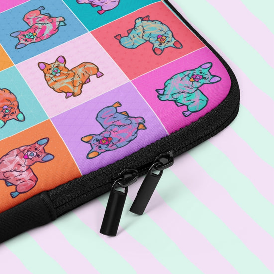 The Crazi Corgis Laptop Sleeve by My Favourite Colour is Rainbow showcases pop art corgis in a vibrant grid pattern. It features a black zipper with two pulls, making it both functional and eye-catching.