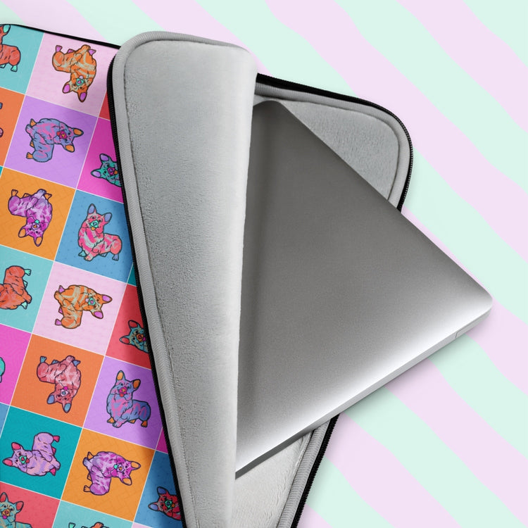 The Crazi Corgis Laptop Sleeve by My Favourite Colour is Rainbow, with vibrant pop art-style design of illustrated corgis on a checkered background in shades of pink, red, orange, blue and teal, makes your laptop a playful tech statement piece.