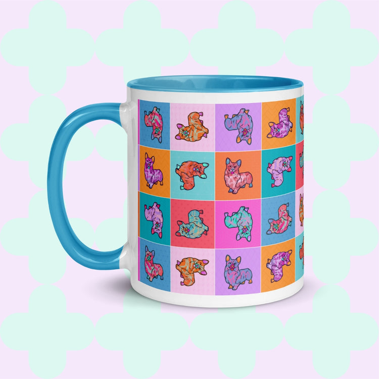 The Crazi Corgis Mug by My Favourite Colour is Rainbow is a vibrant ceramic mug showcasing cartoon corgis on a grid of orange, red, teal, and purple squares. It features a blue handle and pastel green background—ideal for coffee lovers with its whimsical design.