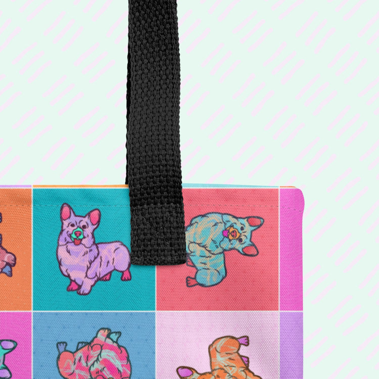 A close up of the Crazi Corgis Tote Bag by My Favourite Colour is Rainbow showing the sturdy black strap.  It features pop art corgis in colourful squares, making it spacious and stylish for any outing. 