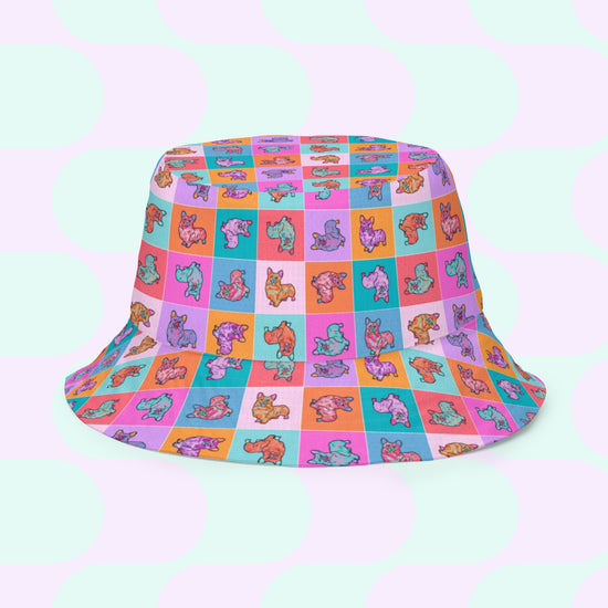 The Crazi Corgis Reversible Bucket Hat by My Favourite Colour is Rainbow is a vibrant streetwear accessory. It features playful cartoon dogs on a breathable fabric, with a colorful background of blue, purple, pink, and orange squares.