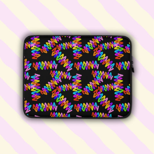 The Electric Zigzag Laptop Sleeve from My Favourite Colour is Rainbow features vibrant red, yellow, blue, pink, and green zigzags on a black backdrop.