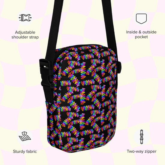 My Favourite Colour is Rainbows Electric Zigzag Mini Crossbody Bag features a striking print with an adjustable strap, inside and outside pockets, durable fabric, a two-way zipper, and a light checkered background for extra style.