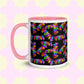 The Electric Zigzag Mug by My Favourite Colour is Rainbow features a pink handle and rim with colorful zigzag patterns of vibrant reds, greens, blues, and yellows on a soft pastel backdrop, perfect for your coffee break.