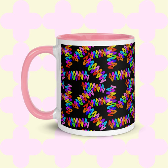 The Electric Zigzag Mug by My Favourite Colour is Rainbow features a pink handle and rim with colorful zigzag patterns of vibrant reds, greens, blues, and yellows on a soft pastel backdrop, perfect for your coffee break.