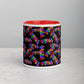 The Electric Zigzag Mug by My Favourite Colour is Rainbow features a black exterior with a colorful zigzag pattern and a red ceramic interior, offering vibrant contrast on a light gray textured surface—ideal for any coffee break.