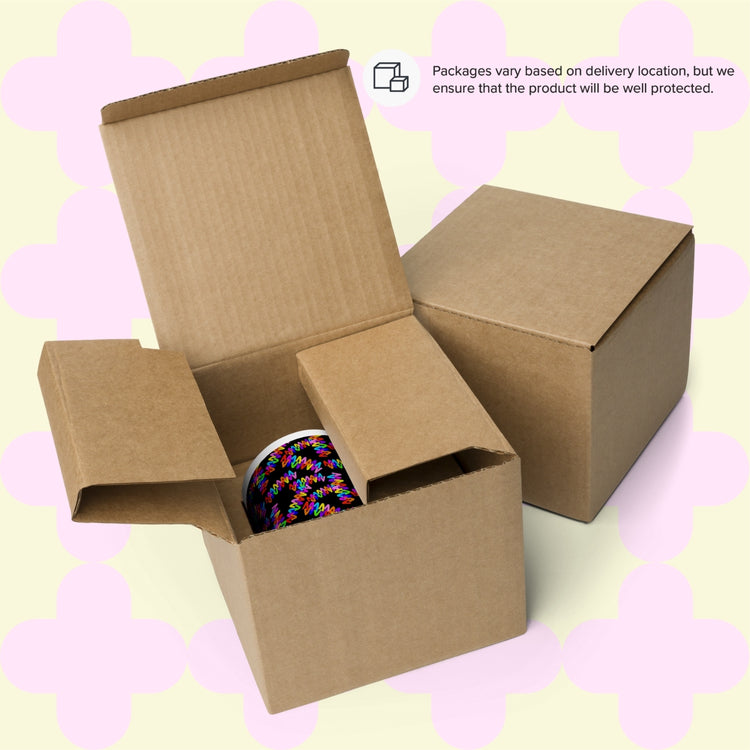 A cardboard box brimming with colorful thread spools sits open on a patterned backdrop next to an Electric Zigzag Mug by My Favourite Colour is Rainbow. A closed box lies nearby. Text assures, Packages vary by delivery location, but we ensure product protection.