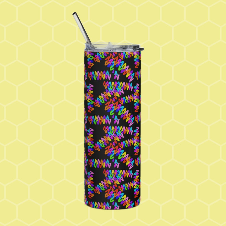 The Electric Zigzag Stainless Steel Tumbler by My Favourite Colour is Rainbow, featuring a vibrant multicolored abstract zigzag pattern on a black base with lid and reusable metal straw, is showcased against a yellow honeycomb-patterned background.