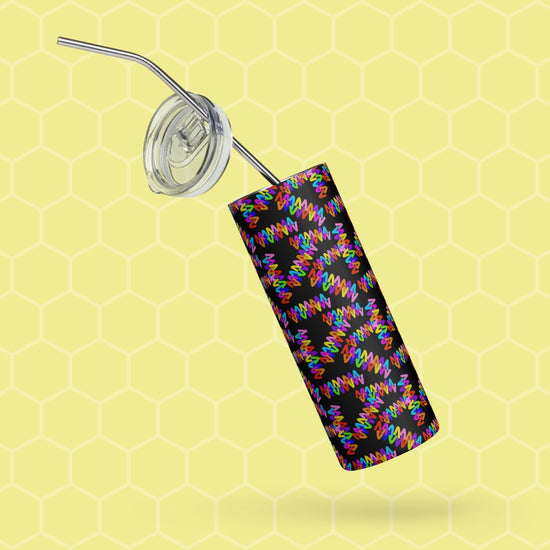 The Electric Zigzag Stainless Steel Tumbler by My Favourite Colour is Rainbow features a vibrant spiral on black, includes a transparent lid and metal straw, and is set against a striking yellow honeycomb-patterned background.