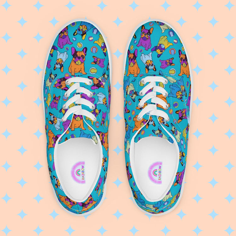 The Frenchie Fetch, Set, Match Canvas Sneakers by My Favourite Colour is Rainbow are vibrant women's lace-up shoes with orange, purple, yellow and blue french bulldogs and tennis balls, set against a bright blue background.  The inside of the shoe is white with My Favourite Colour is Rainbow branding on the footbed.  They have white laces and soles.