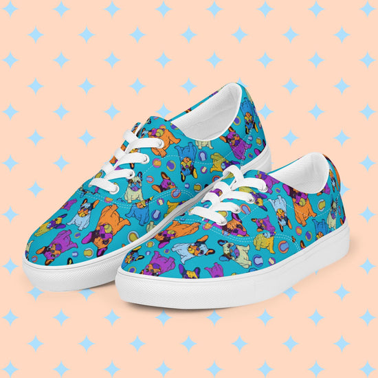 The Frenchie Fetch, Set, Match Canvas Sneakers by My Favourite Colour is Rainbow, with orange, purple, yellow and blue french bulldogs and tennis balls, set against a bright blue background.  They have white laces and soles.