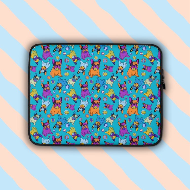 The Frenchie Fetch, Set, Match Laptop Sleeve by My Favourite Colour is Rainbow turns tech accessories into a statement piece with a print featuring purple, orange, yellow and blue french bulldogs and tennis balls on a blue backdrop. The print is on only one side of the laptop sleeve, the other side is black.