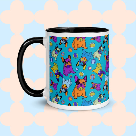 The Frenchie Fetch, Set, Match Mug by My Favourite Colour is Rainbow features colorful cartoon French bulldogs and balls on a light blue backdrop with a peach geometric pattern, complemented by a contrasting black handle.