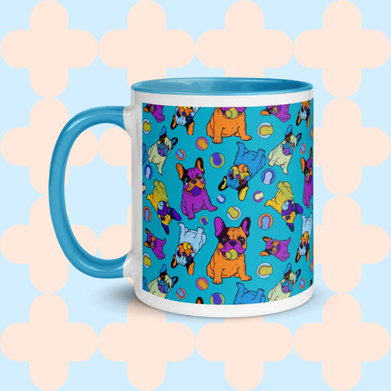 The Frenchie Fetch, Set, Match Mug by My Favourite Colour is Rainbow features a charming design of cartoon-style French bulldogs playing fetch against a turquoise backdrop. These playful Frenchies in orange, purple, and green are complemented by a blue interior and handle.