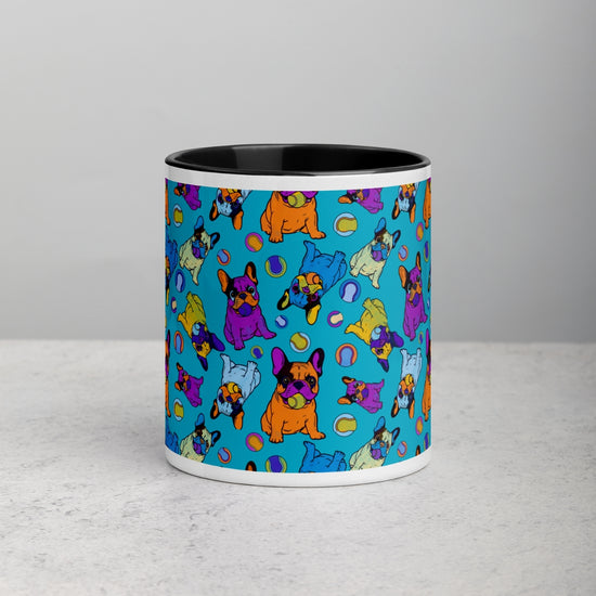 The Frenchie Fetch, Set, Match Mug by My Favourite Colour is Rainbow features a playful cartoon French Bulldog pattern in vibrant purple, orange, and green on a blue backdrop. Its sleek black handle and interior add an elegant touch to the fun design.