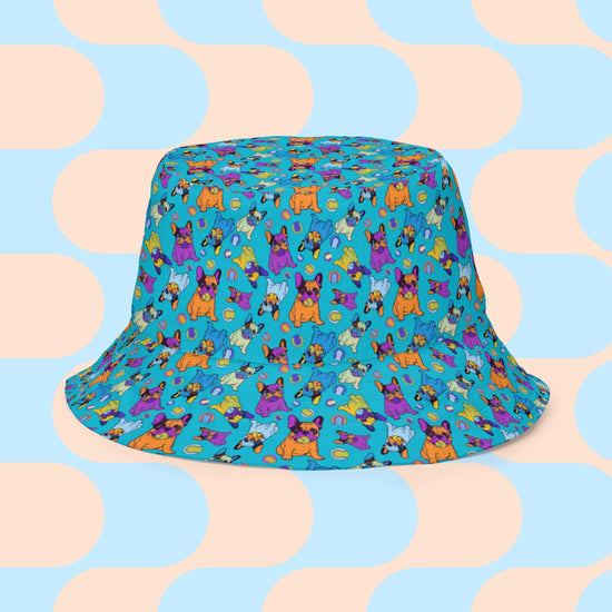 My Favourite Colour is Rainbow presents the Frenchie Fetch, Set, Match Reversible Bucket Hat with cartoon dogs on a bright blue background and a pastel blue and peach geometric design on the reverse. Made from breathable fabric for ultimate comfort and style.