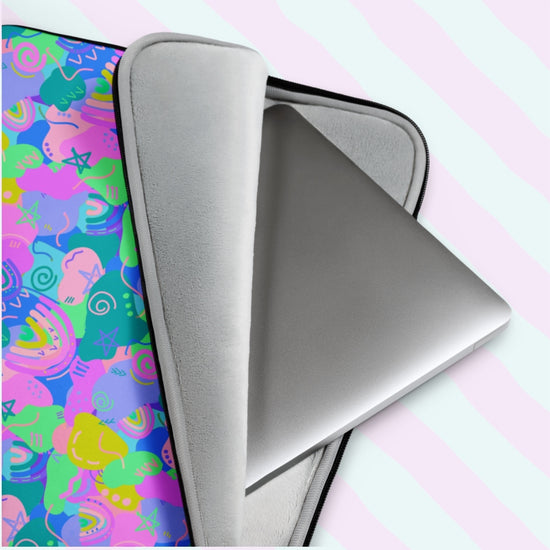 The slightly open Funfetti Laptop Sleeve by My Favourite Colour is Rainbow reveals a silver laptop. Its exterior features an abstract design with vibrant pink, green, blue, and yellow shapes and swirls, ideal for stylish tech enthusiasts seeking a standout accessory.  The print is on only one side of the laptop sleeve, the other side is black.