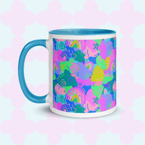 The Funfetti Mug by My Favourite Colour is Rainbow is crafted from ceramic and showcases a colorful abstract pattern of stars, hearts, and rainbows in pink, blue, yellow, and green on a light blue backdrop with pink quatrefoil shapes and a bold blue handle.