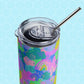 The Funfetti Stainless Steel Tumbler from My Favourite Colour is Rainbow features vibrant abstract patterns in pink, blue, green, and purple. It pairs perfectly with a sleek metal straw and is shown against a light blue hexagonal backdrop.