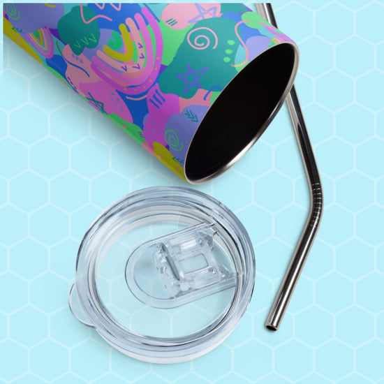 The Funfetti Stainless Steel Tumbler by My Favourite Colour is Rainbow, featuring abstract designs, sits on a hexagonal-patterned surface. Beside it are a transparent lid and metal straw, ideal for sipping your favorite chilled drink.