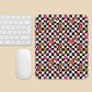 A wireless keyboard and mouse are next to the Galaxy Mouse Pad by My Favourite Colour is Rainbow, featuring a vibrant geometric pattern of stars, checkerboard squares, and textured shapes on a light beige background.