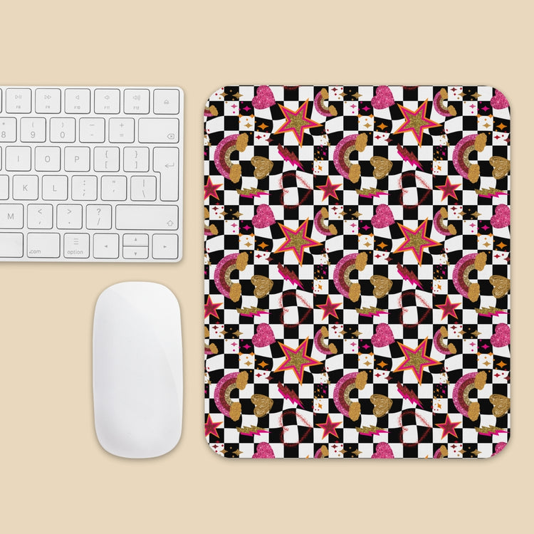 A wireless keyboard and mouse are next to the Galaxy Mouse Pad by My Favourite Colour is Rainbow, featuring a vibrant geometric pattern of stars, checkerboard squares, and textured shapes on a light beige background.