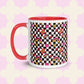 The Galaxy Mug by My Favourite Colour is Rainbow, crafted from ceramic, features a vibrant design with a white base, red handle and interior. It is adorned with black and white checkerboards, red stars, golden hearts, rainbows on a light pink background with white clovers.