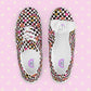 A top view of My Favourite Colour is Rainbows Galaxy Canvas Sneakers, decorated with a black and white checkerboard print, featuring gold, pink and red stars, hearts and rainbows.  They are complemented by white laces and soles.  The underside of the shoe tongue has a shoe size sticker and the inside of the shoe is white with My Favourite Colour is Rainbow branding on the footbed.
