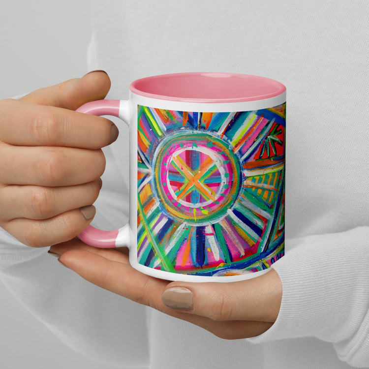 A person in a white sweater holds the Geometric Rainbow Mug by My Favourite Colour is Rainbow, featuring a pink interior and handle with abstract colorful circular and linear patterns, set against a plain background.