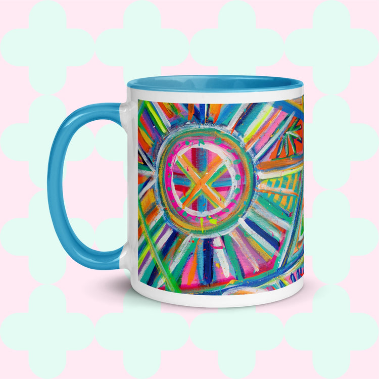 Introducing the Geometric Rainbow Mug by My Favourite Colour is Rainbow: a ceramic masterpiece featuring colorful circular patterns, an abstract painting with lines, light blue handle and interior, set on a pastel pink backdrop adorned with mint green clover shapes.