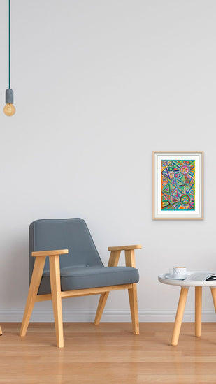 A minimalist interior features a wooden armchair with gray upholstery and a small round table. A colorful Geometric Rainbow Fine Art Print by My Store adorns the white wall beneath a bare bulb light. A cup sits on the table atop the wooden floor, adding elegance to the serene space.