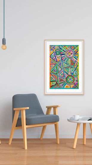 A modern living room showcases a gray armchair and a small round wooden table. The Geometric Rainbow Fine Art Print by My Store, framed on the white wall, adds a colorful abstract touch. A single pendant light with an exposed bulb hangs above.