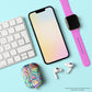 Flat lay of a keyboard, smartphone with a gradient screen, pink smartwatch, and AirPods in My Favourite Colour is Rainbows impact-absorbing Geometric Rainbow case on a light background.