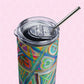 The Geometric Rainbow Stainless Steel Tumbler by My Favourite Colour is Rainbow, featuring a clear lid and metal straw, is showcased against a light pink hexagonal background.