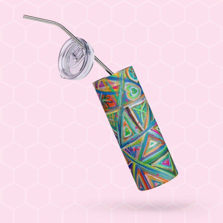 The Geometric Rainbow Stainless Steel Tumbler by My Favourite Colour is Rainbow features a geometric design, metal straw, and transparent reusable lid. It sits against a light pink hexagonal background.